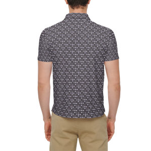 Person wearing a patterned shirt and beige pants on a white background